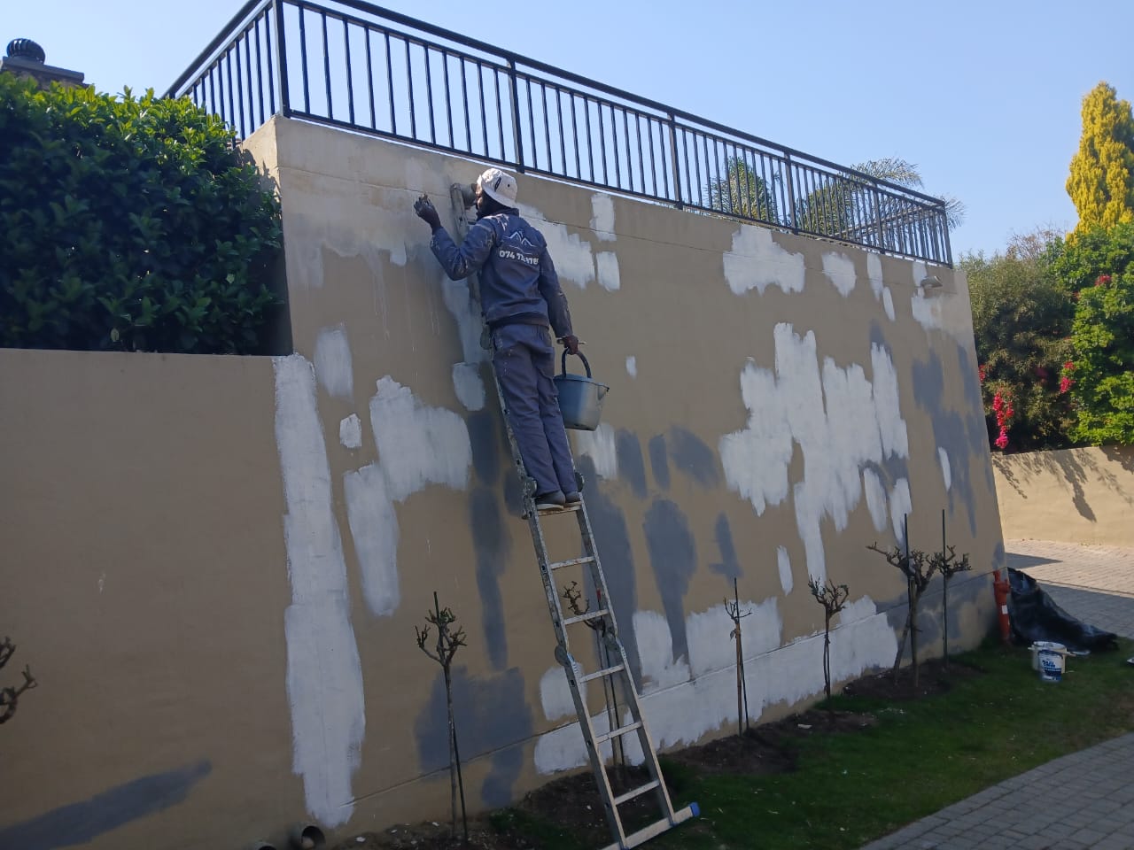 JMProjects painter preparing a boundary wall for repainting in Gauteng